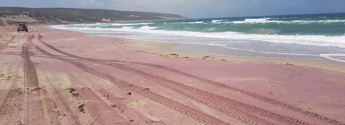 Red-tinged sand at Broken Anchor Bay.