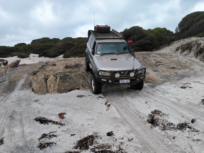 Scott takes his Patrol over the rock ledge onto Starvation Harbour Beach.
